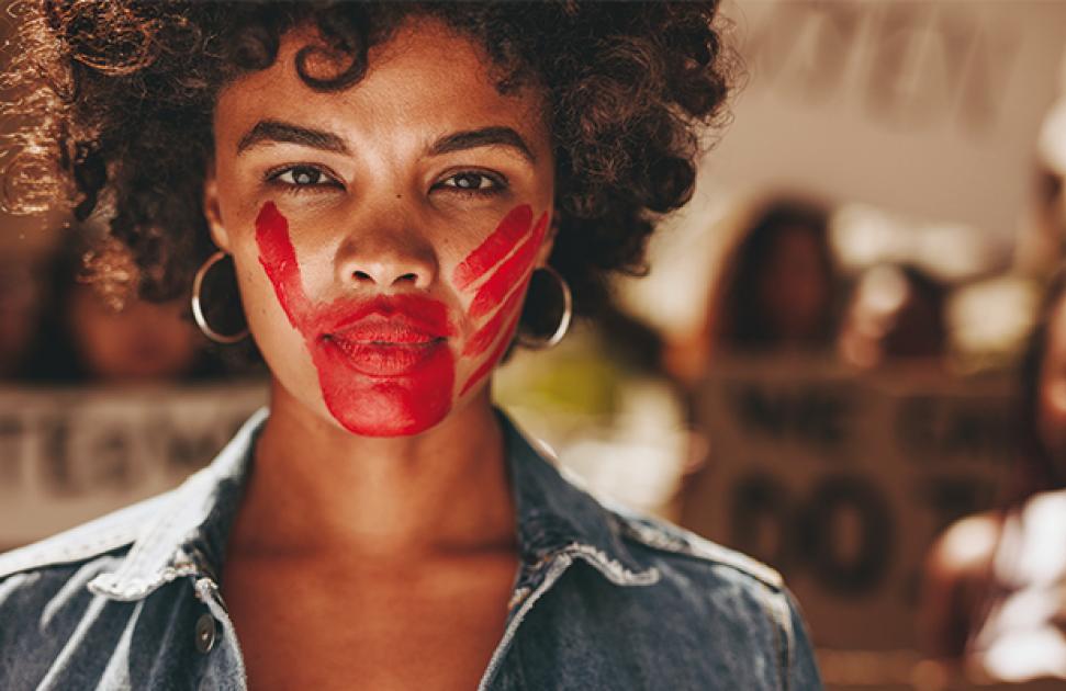 Main rouge sur visage de femme